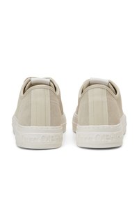 Sneakers in suede beige con finitura testurizzata, dotati di suole in gomma bianca e logo impresso sul tallone. Silhouette arrotondata con anelli sul retro.
