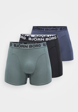 Três pares de boxers BJÖRN BORG em cinza escuro, azul marinho e verde-azulado. Cada um apresenta uma cintura elástica preta com o logótipo branco e uma textura de tecido suave.