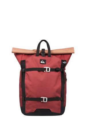 Czerwono-czarny plecak z zamknięciem na rolkę, beżową wewnętrzną podszewką, przednimi klamrami, boczną kieszenią na zamek oraz górnym uchwytem.