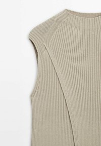 Sukienka bez rękawów z dzianiny w jasnym beżu, wyróżniająca się żeberkową teksturą, okrągłym dekoltem i unikatowym otwartym tyłem z wyraźnymi szwami przy ramionach.