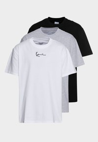 Tre T-shirts: en vit med en svart logotyp, en grå och en svart. Alla har korta ärmar och en klassisk rund halsringning. Materialet är bomull.