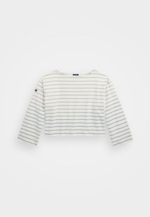 Hvit avkortet skjorte med lange ermer og lyseblå horisontale striper. Har en rund hals og en liten logo på venstre erme.