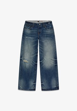 Jean en denim bleu à jambes larges avec des zones décolorées et usées, avec poches avant et ceinture à bouton.