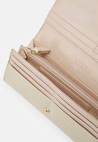 Valentino wallet in beige and nude leather with a textured finish, featuring card slots, a zippered pocket, and gold hardware accents.