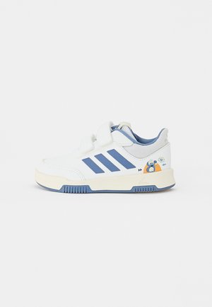 Białe sneakersy z niebieskimi akcentami, z trzema niebieskimi paskami, z zapięciem na rzepy oraz z rysunkowym wzorem po zewnętrznej stronie.