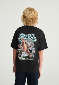 Sort bomulds-T-shirt med et farverigt motiv af en muskuløs bananfigur med teksten "DEEPLY" og Fortnite-branding på bagsiden.