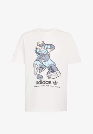 Witte katoenen T-shirt met een afbeelding van een beer in een blauw hockeytenue, die een stick vasthoudt, met het Adidas-logo en de slogan eronder gedrukt.