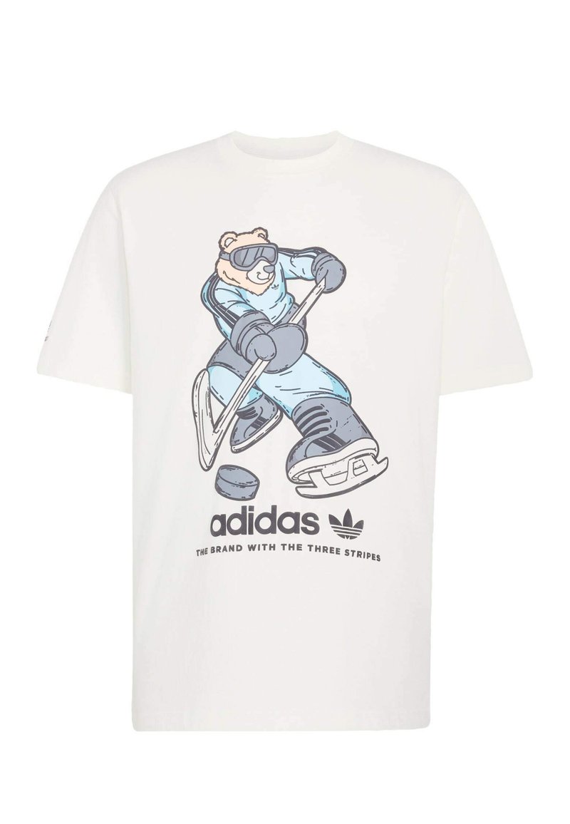 Vitt bomulls-T-shirt med en bild av en björn i hockeyutrustning i blått som håller i en klubba, med Adidas-logotypen och slogan tryckt nedanför.