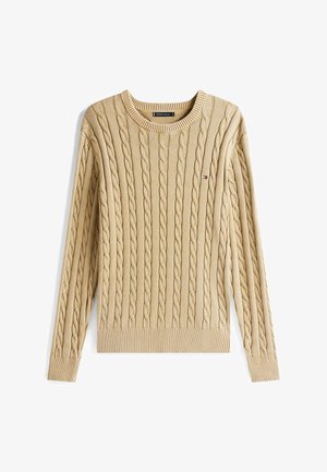 Beige kabelgebreide trui met een ronde halslijn, geribde manchetten en onderrand, met een klein logo op de borst. Zachte textuur, lange mouwen.
