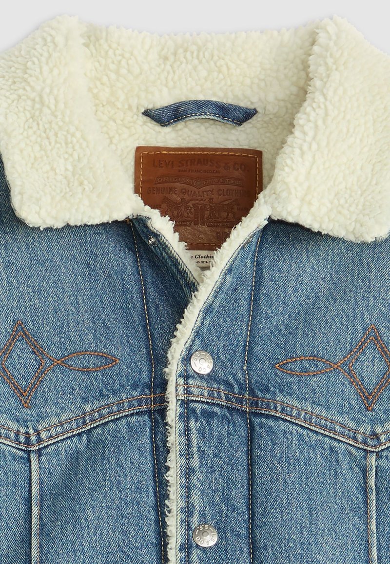 Jeansowa kurtka z kołnierzem z kremowego sztucznego shearlingu. Posiada brązowe przeszycia, skórzaną metkę oraz ozdobne hafty w diamenty na piersi.