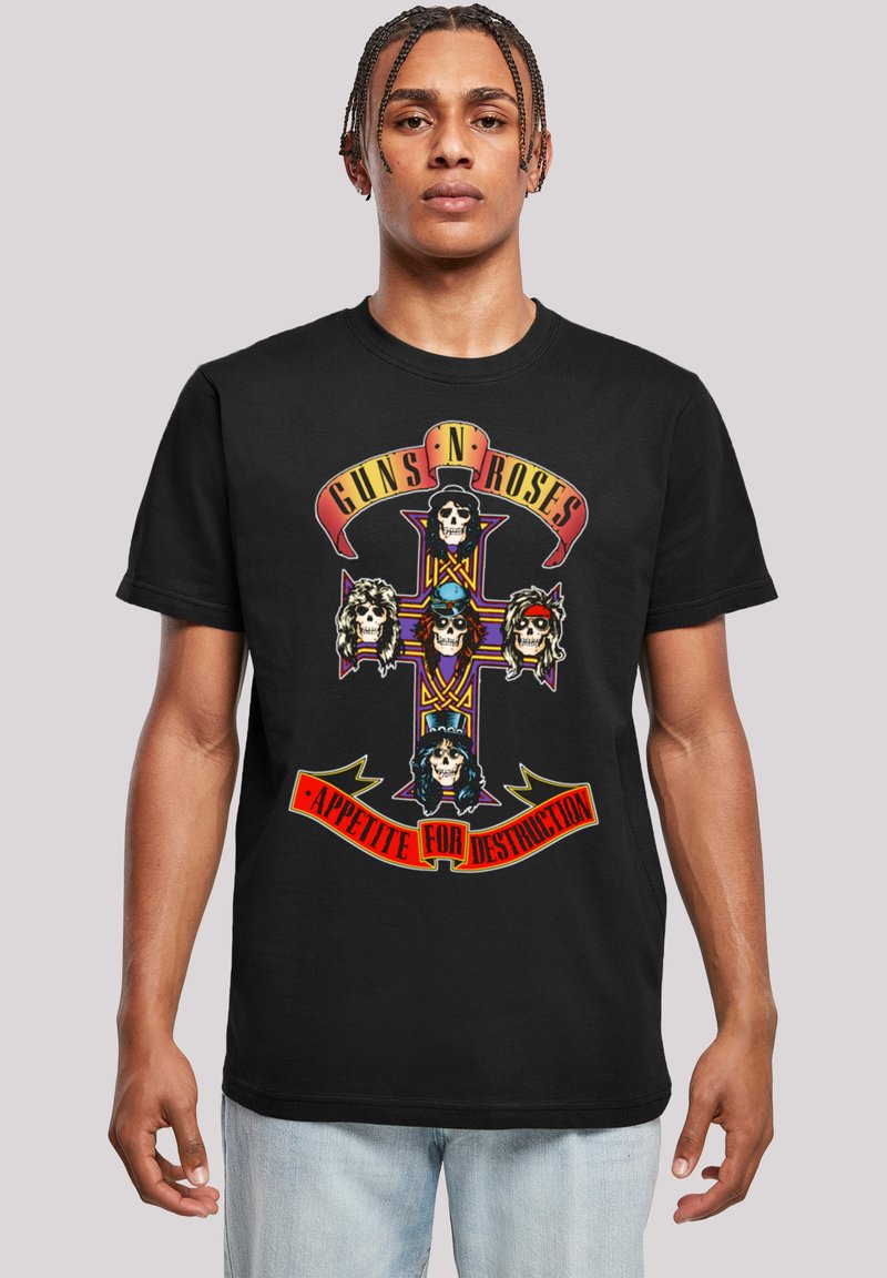 Černé bavlněné tričko s barevnou grafikou na přední straně s křížem, pěti ilustracemi lebek a textem "Guns N' Roses" a "Appetite for Destruction."