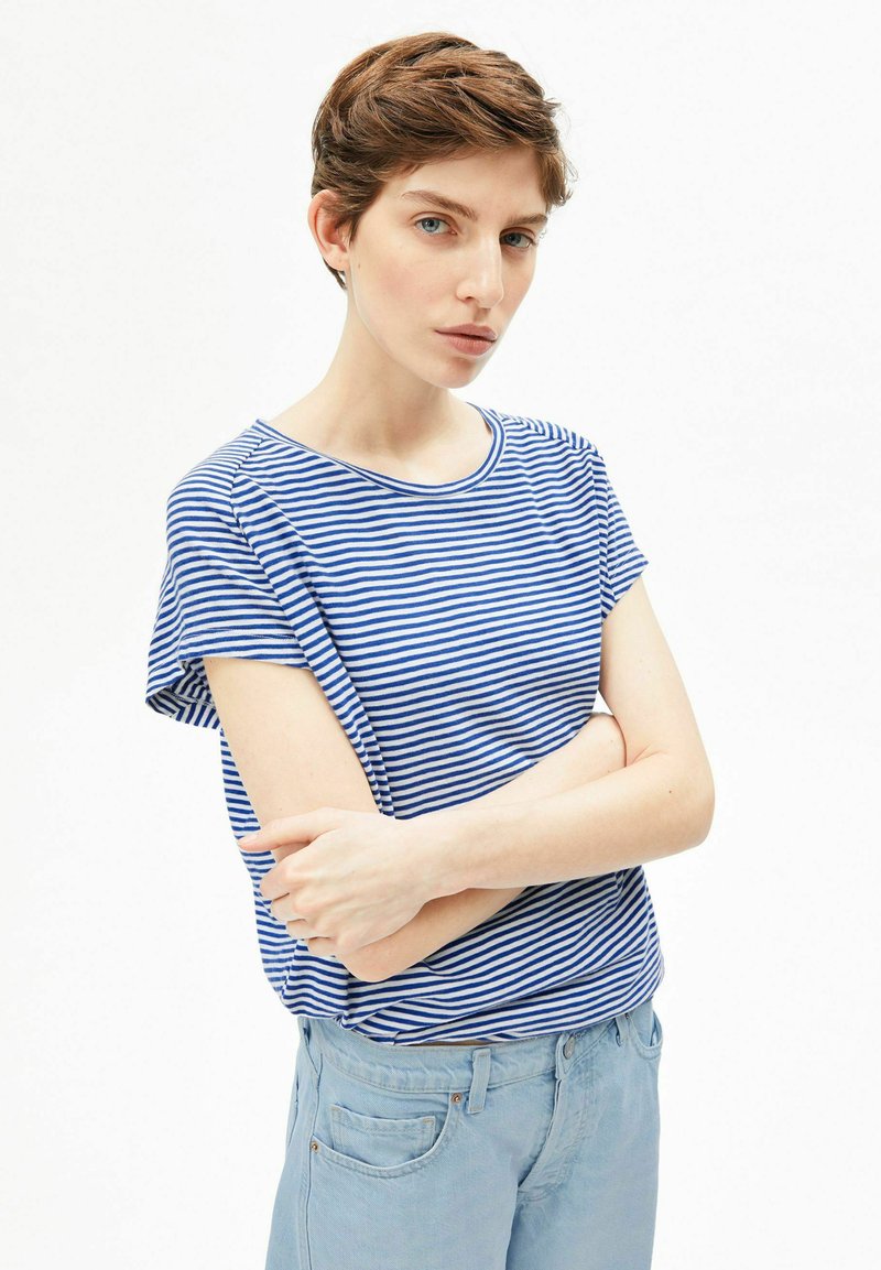 Blauw-wit gestreept katoenen T-shirt met korte mouwen en een ronde hals, gecombineerd met lichtblauwe broek met zijzakken.