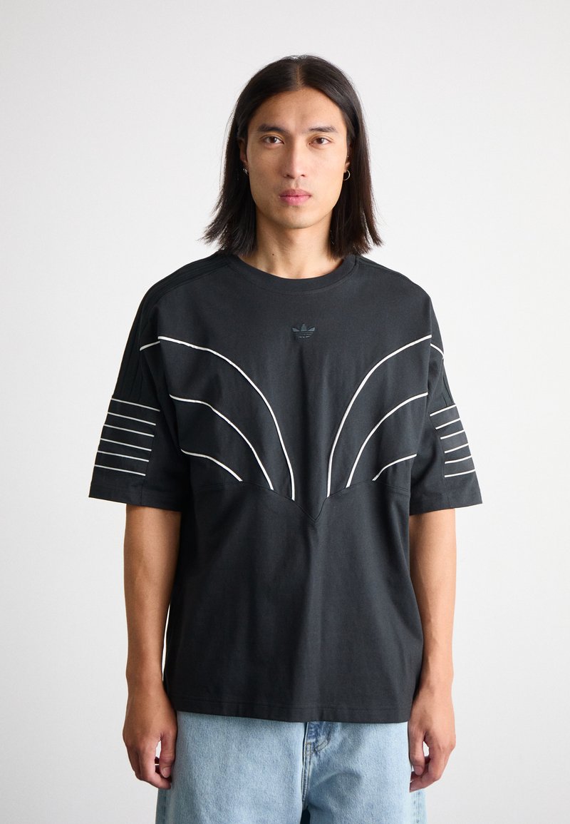 Black cotton t-shirt with white striped accents on sleeves and a curved chest design. Crew neckline. Relaxed fit, solid texture.