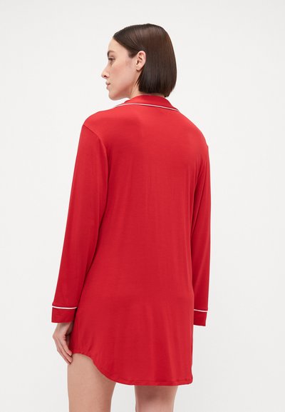Camisa de noite longa vermelha com detalhes brancos no colarinho e nos punhos, tecido suave, corte até aos joelhos e bainha ligeiramente curva.