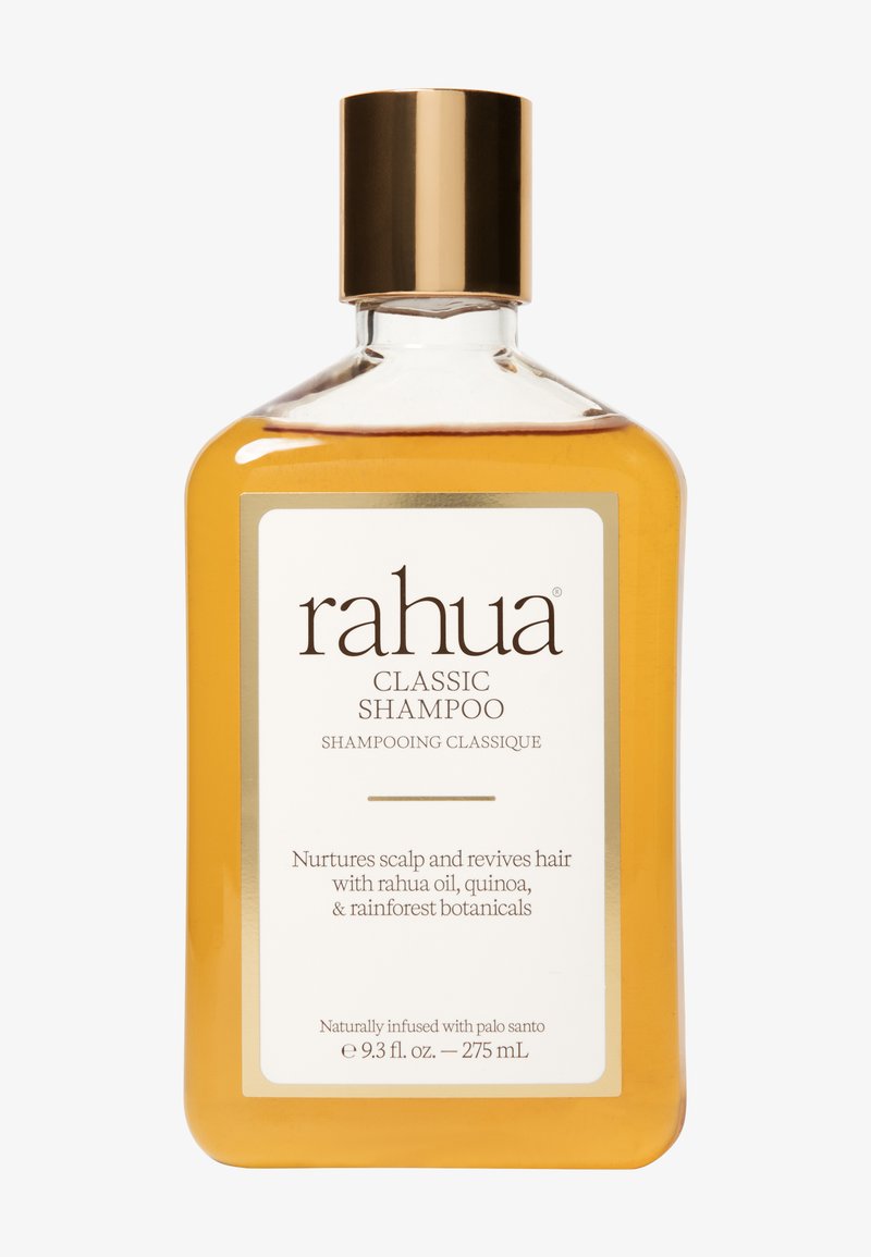 Rahua Classic Shampoo in a transparent rectangular bottle with a gold cap. The liquid is amber-colored, featuring a white label with black text.