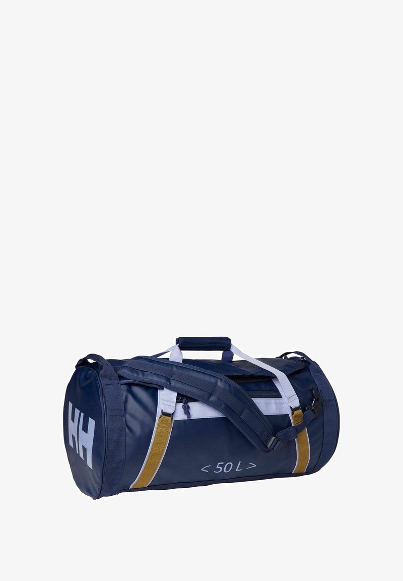 Sac de sport bleu marine en matériau résistant, présentant des accents blancs et dorés, un dessus zippé, des poignées et une bandoulière réglable.