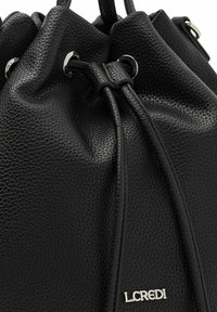 Schwarze Leder-Eimer-Tasche mit strukturiertem Finish, Kordelzugverschluss, silbernen Hardware-Akzenten und einem dezenten Logoplatz auf der Vorderseite.