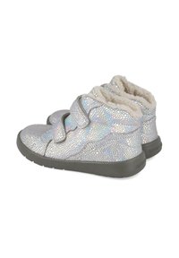 Zapatos plateados texturizados con un patrón agrietado, que cuentan con un forro suave y dos correas de velcro. Suelas de goma gris para mayor estabilidad.