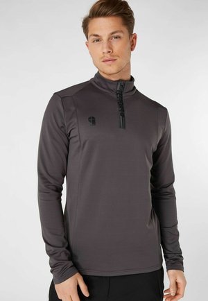Felpa nera con zip, colletto alto, maniche lunghe, texture liscia, con un logo sul lato sinistro del petto e una zip corta sul davanti.