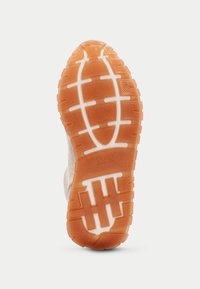 Suela de una zapatilla deportiva con una superficie de goma texturizada de color naranja, acentos blancos y un dibujo en la banda de rodadura para mejor agarre.