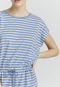 Csíkos pamut felső világoskék és fehér színben, kerek nyakkivágással, rövid ujjakkal és gumírozott derékrésszel, melynek bevarrásán zsinór található.