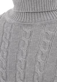 Maglione grigio a collo alto realizzato in maglia, con motivo a trecce, collo a costine e una texture morbida, che mette in evidenza cuciture dettagliate.