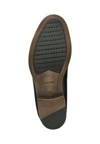 Suola della scarpa Geox in gomma nera con un motivo testurizzato, caratterizzata da un accento marrone e logo, progettata per offrire comfort e traspirabilità.