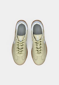 Beige ruskind Converse All Star sneakers med lyseblå detaljer og gummisåler i naturlig farve, set oppefra mod en hvid baggrund.