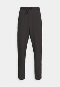 Pantalon de jogging noir avec une ceinture élastique et un cordon de serrage ajustable. Confectionné dans un tissu lisse et léger avec une coupe fuselée.