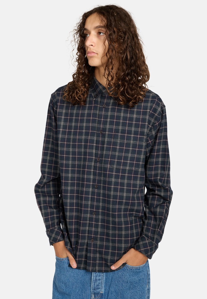 Tjekket skjorte i marineblå og grøn med rosa accenter. Lange ærmer, krave, knaplukning fortil og afslappet pasform. Tekstureret bomulds-flannel stof.