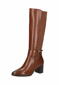 Bottes en cuir marron montant jusqu’au genou avec un panneau en daim, bout pointu, une sangle avec une boucle en argent et un talon bloc. Surfaces lisses et texturées.