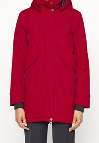 Parka impermeable roja con cierre de cremallera y botones a presión, capucha ajustable, dos bolsillos en el frente y puños elásticos. Tejido texturizado con un acabado suave.