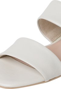 Sandal in cuoio bianco con due ampie cinghie, design con punta aperta e soletta beige morbida, caratterizzata da una texture liscia e un'estetica minimalista.