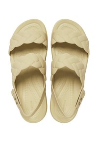 Infradito beige con cinturini intrecciati, realizzati in materiale morbido. Presentano una soletta testurizzata e chiusure laterali regolabili.