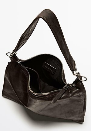 Borsa a mano in pelle nera con una sola tracolla e chiusura con zip. L'interno presenta una fodera in tessuto semplice e un'etichetta. Texture liscia.