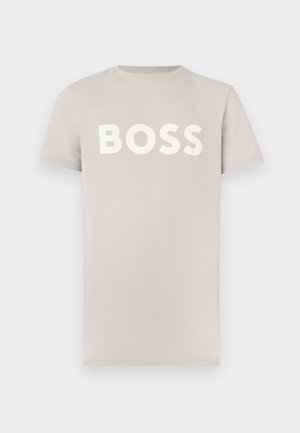 Svetložlté bavlnené tričko s krátkymi rukávmi a okrúhlym výstrihom. Na hrudi má výrazný biely nápis „BOSS“. Hladká textúra.