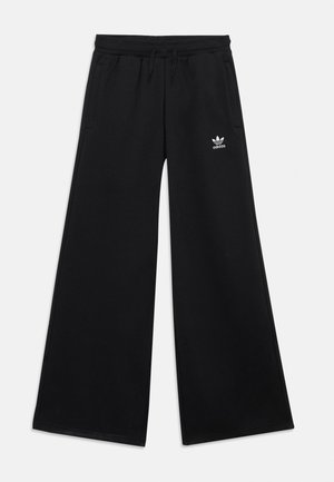 Sorte Adidas bukser med vide ben, elastisk talje, snøre, sidelommer og hvid Adidas-logo på venstre lår.