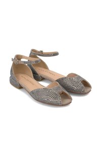 Zilveren suède ballerina's met open teen, versierd met metalen studs. Inclusief verstelbare enkelband en lage blokhak. Gladde binnenkant.