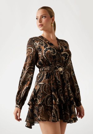 Vestido negro con estampado de paisley, de manga larga, con cintura ajustada, dobladillo con volantes y acento dorado. Hecho de una tela ligera y translúcida con patrones intrincados.
