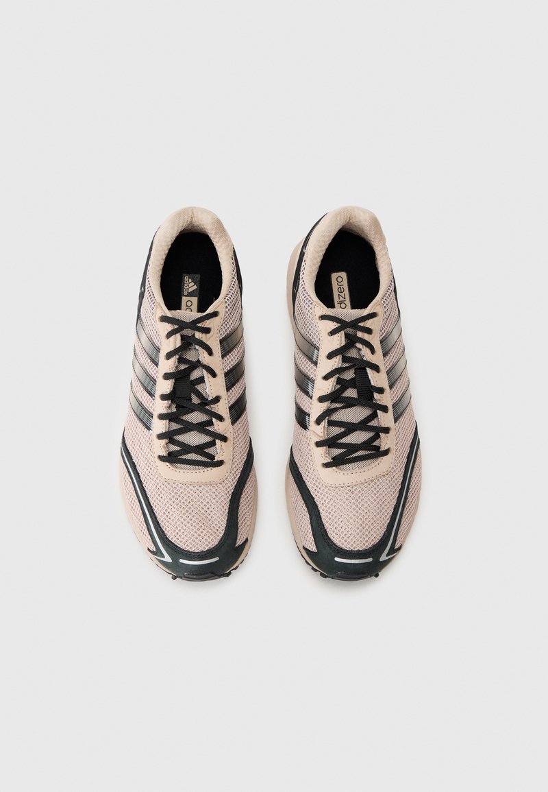 Light pink mesh athletic shoes with black accents, featuring three black stripes, black laces, and a textured sole.