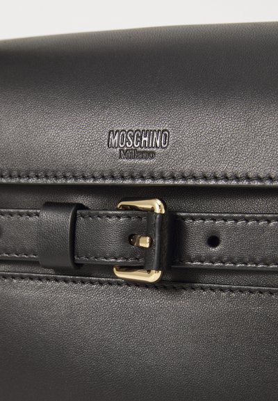 Schwarze Lederhandtasche mit strukturiertem Finish, ausgestattet mit einer goldenen Schnallendetail und dem geprägten "Moschino Milano"-Logo. Kompakte Bauweise mit klaren Linien.