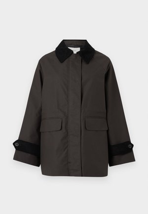 Donkere bruine jas van gladde stof met een zwarte corduroy kraag. Heeft twee voorzakken en zwarte ribgebreide manchetten met knopen.