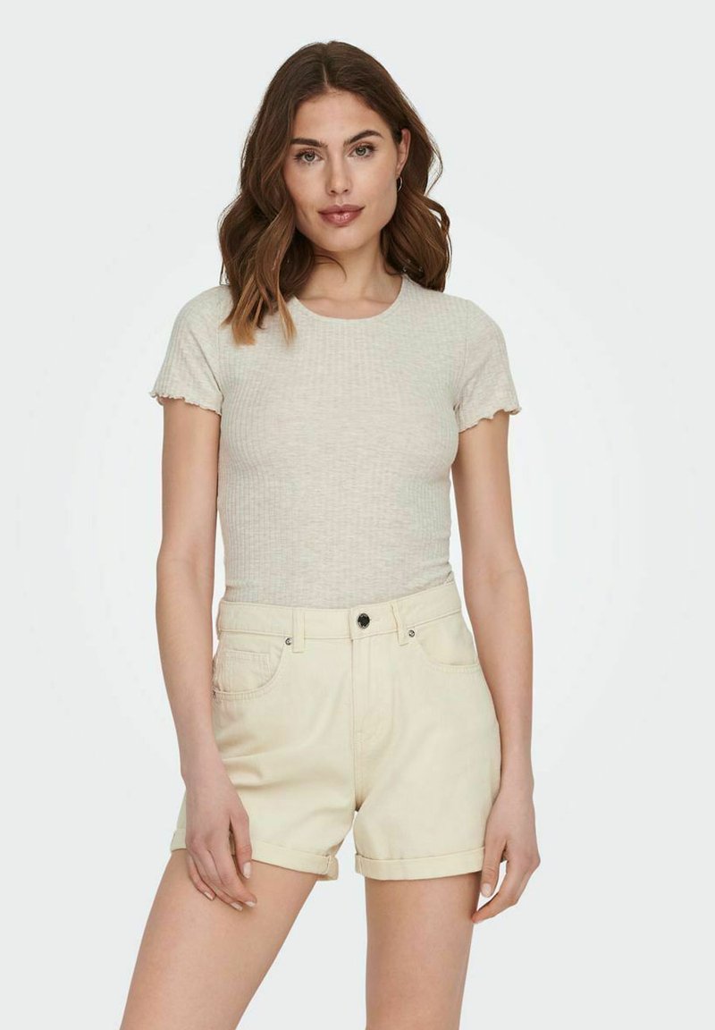 Lys grå ribbet t-skjorte med bølgete korte ermer, kombinert med beige denimshorts. Plagget har en tettsittende fasong og minimal detaljering.