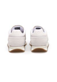 Baskets de sport blanches avec des accents en daim et en maille, talon rembourré et semelle en caoutchouc. Présente un logo à l'arrière, au design minimaliste.