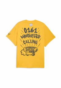Gul bomulds T-shirt med grafisk design af en vintage telefon, teksten "0161 MANCHESTER CALLING" og et logo på den øverste ryg.