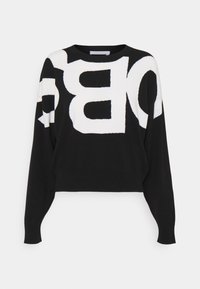 Pull noir à manches longues avec de grandes lettres blanches abstraites sur le devant et les manches, encolure ronde et coupe décontractée.