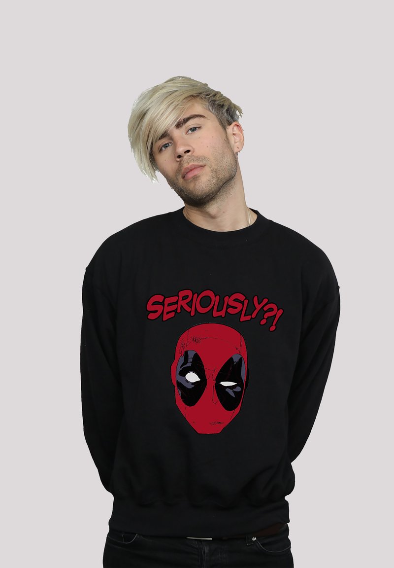 Svart hettegenser med et rødt Deadpool-ansikt grafikk og teksten "SERIOUSLY?!" i fet rød. Laget av bomull, avslappet passform, ribbestrikkede mansjetter.