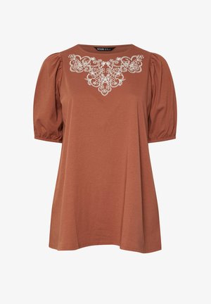 Haut pour femme couleur rouille avec manches courtes bouffantes et broderie florale blanche autour du col.