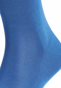 Calcetín azul con una textura lisa y acanalada, que presenta un diseño ajustado que se adapta al pie y al tobillo, destacando un color uniforme en toda su superficie.