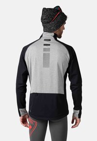Männer Sportjacke mit grauen und marineblauen Paneelen, hohem Kragen, Reißverschluss-Taschen und vertikalen Streifendetails auf dem Rücken.